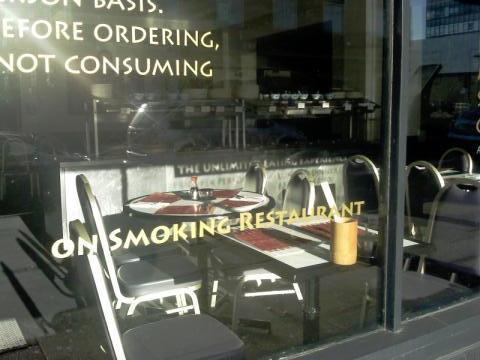 Text on the window of a restaurant reads ''ON SMOKING RESTAURANT''